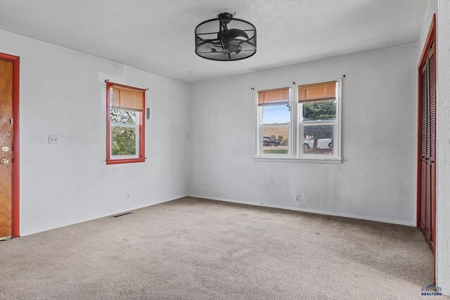 235 E E St, Patrick, Rapid City, SD 57701 - carpeted empty room featuring baseboards, visible vents, and ceiling fan