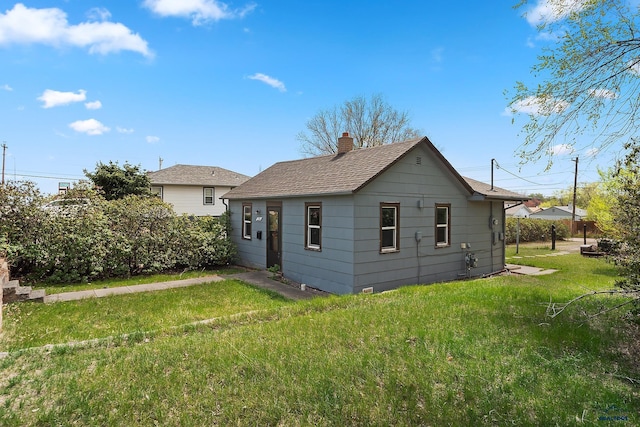 235 E E St, Patrick, Rapid City, SD 57701 - rear view of house with a lawn, a chimney, and a shingled roof