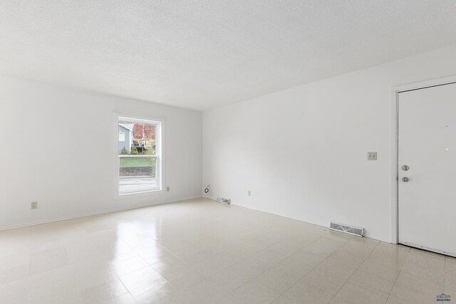 1937 Hillsview Dr, Rapid City, SD 57702 - spare room with tile patterned floors, a textured ceiling, and visible vents