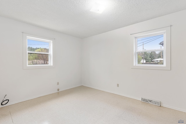 1937 Hillsview Dr, Rapid City, SD 57702 - spare room featuring a textured ceiling, visible vents, a healthy amount of sunlight, and baseboards