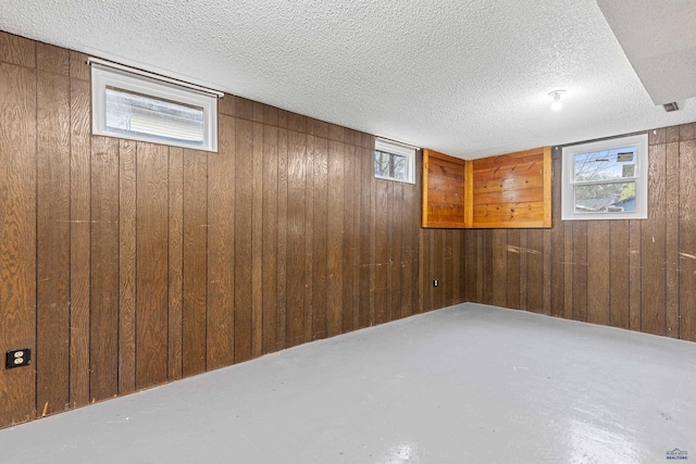 1937 Hillsview Dr, Rapid City, SD 57702 - below grade area featuring wooden walls, a textured ceiling, and plenty of natural light