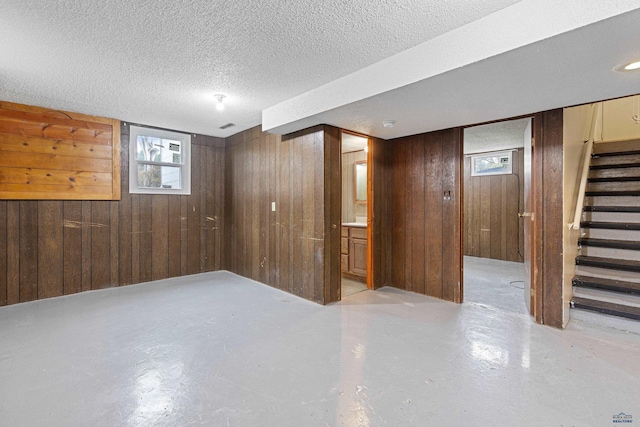 1937 Hillsview Dr, Rapid City, SD 57702 - below grade area featuring wood walls, stairway, and a textured ceiling