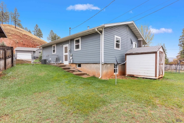 1937 Hillsview Dr, Rapid City, SD 57702 - back of property with an outdoor structure, a yard, a fenced backyard, cooling unit, and a storage shed