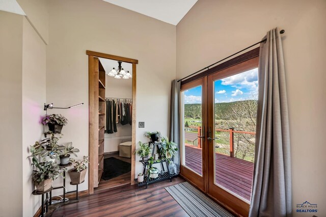 entryway featuring an inviting chandelier, french doors, and dark wood-type flooring