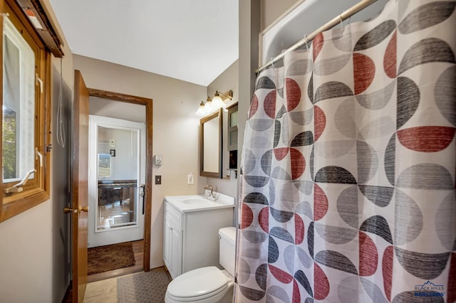 bathroom featuring toilet, vanity, and a shower with curtain