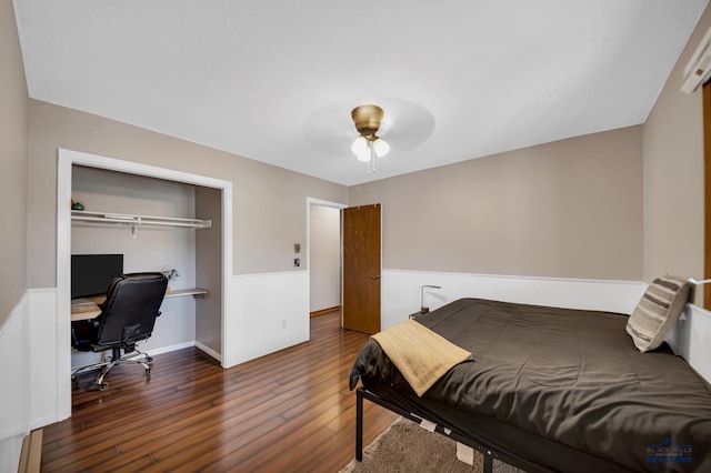 bedroom with wood finished floors, ceiling fan, and a closet