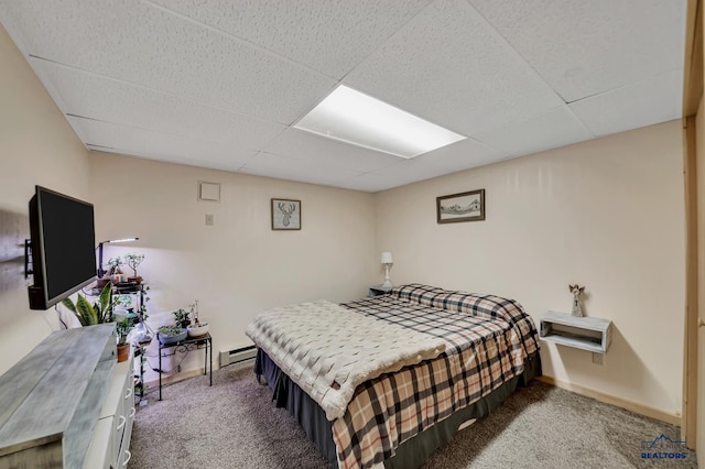 bedroom with a drop ceiling, baseboards, a baseboard heating unit, and carpet floors
