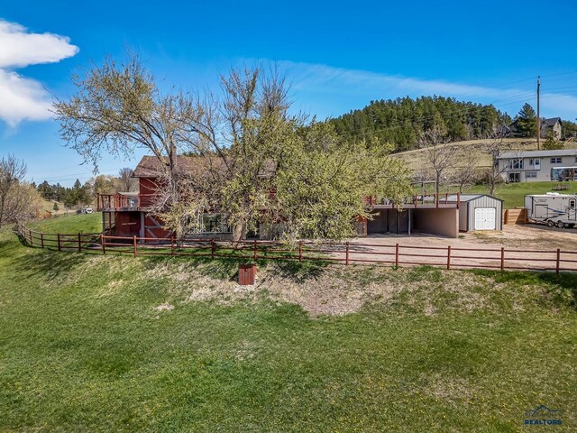 view of yard featuring an outbuilding, a garage, and fence