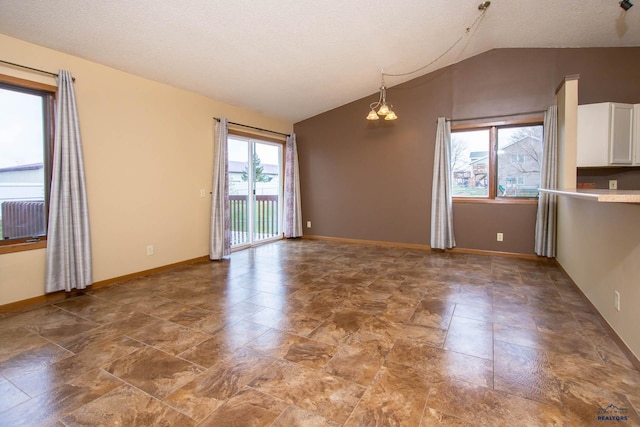 4028 Prairie View Dr, Rapid City, SD 57701 - interior space with an inviting chandelier, stone finish floor, vaulted ceiling, baseboards, and a textured ceiling