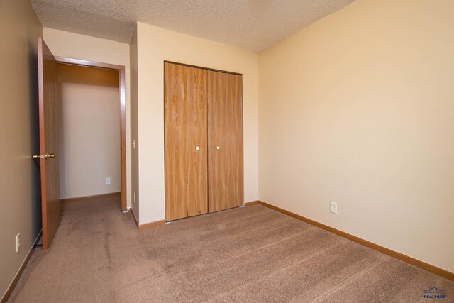 4028 Prairie View Dr, Rapid City, SD 57701 - unfurnished bedroom with a closet, baseboards, carpet, and a textured ceiling