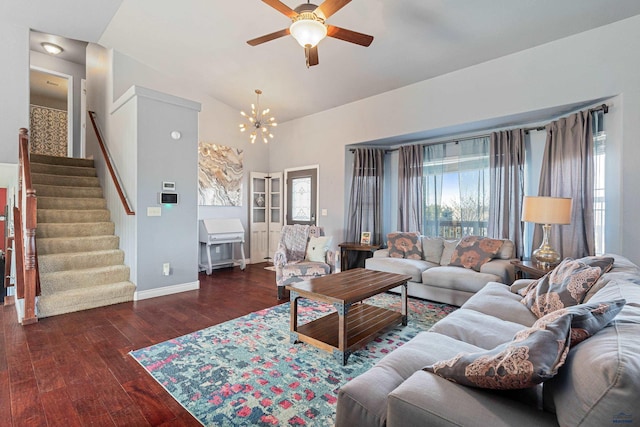 living room featuring stairway, wood finished floors, baseboards, lofted ceiling, and ceiling fan with notable chandelier