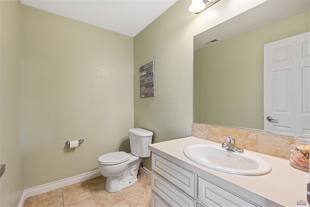 bathroom with visible vents, baseboards, toilet, vanity, and tile patterned flooring