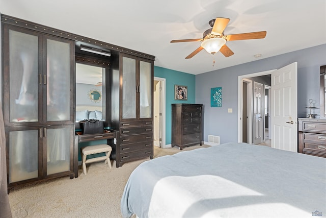 bedroom featuring baseboards, visible vents, ceiling fan, and light colored carpet