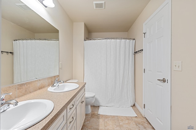 full bath featuring toilet, double vanity, a sink, and visible vents