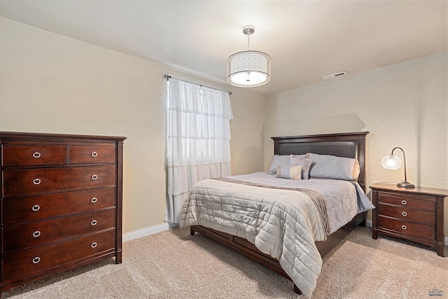 bedroom with visible vents, light carpet, and baseboards