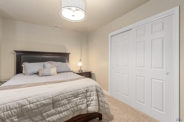 bedroom with a closet, visible vents, and carpet