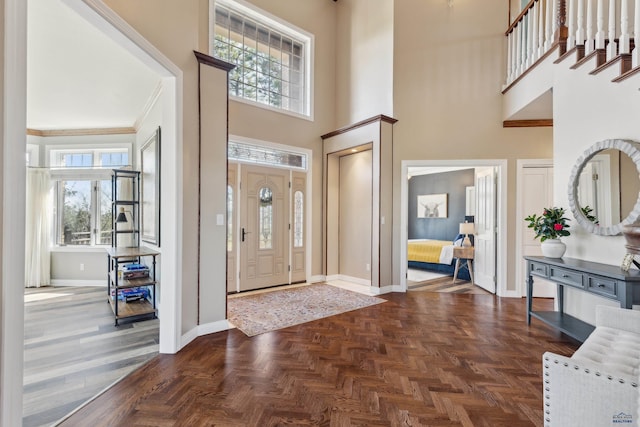 entrance foyer featuring a healthy amount of sunlight, baseboards, and a high ceiling