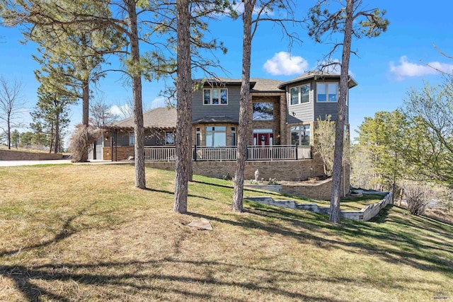 rear view of property with a lawn and brick siding