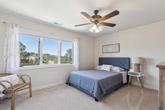 bedroom featuring visible vents, multiple windows, and light carpet
