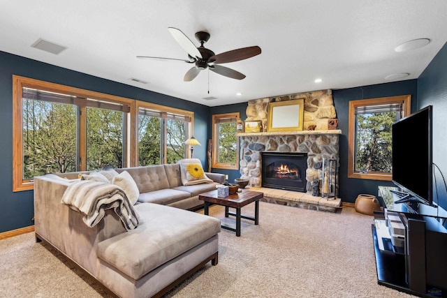 living area featuring ceiling fan, a fireplace, carpet, baseboards, and visible vents