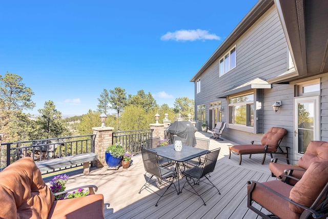 deck with outdoor dining space and area for grilling