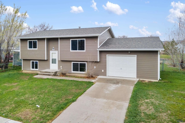 split foyer home with fence, concrete driveway, a front lawn, and a garage