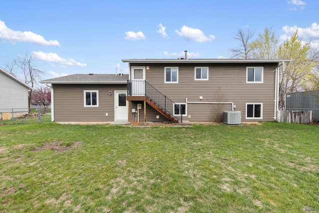 back of property featuring a yard, central AC, and fence