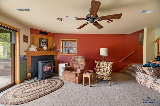 20842 Legacy, Sturgis, SD 57785 - sitting room featuring visible vents, a wood stove, ceiling fan, stairway, and carpet
