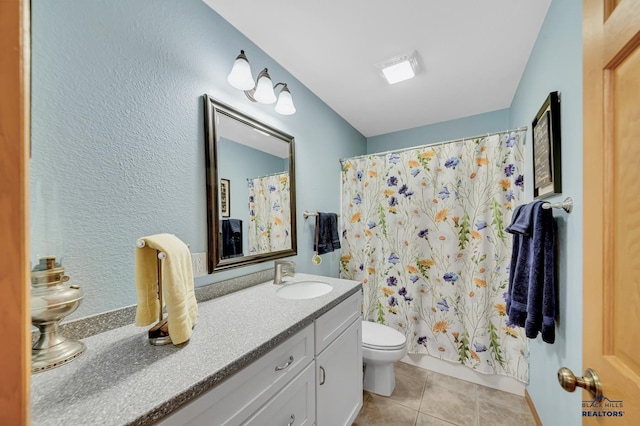 bathroom with vanity, tile patterned flooring, and toilet