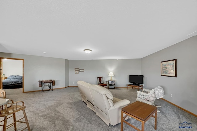 carpeted living area with baseboards