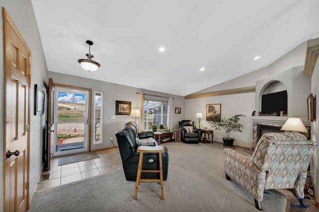 living area with recessed lighting, a glass covered fireplace, vaulted ceiling, and light colored carpet