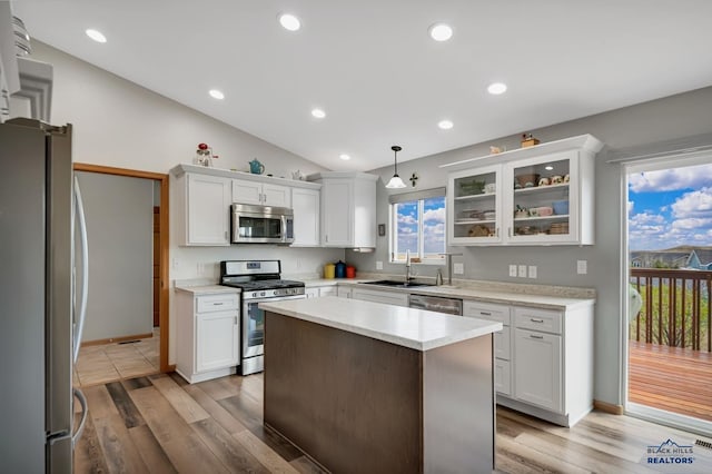 kitchen featuring white cabinets, stainless steel appliances, a sink, and light wood finished floors