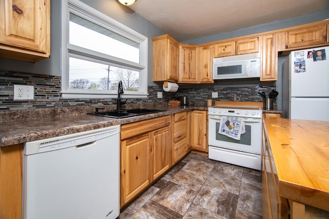 kitchen featuring a sink, butcher block counters, backsplash, and white appliances