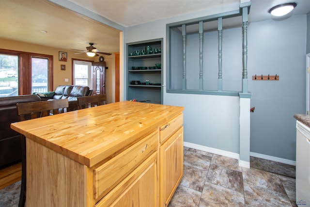 kitchen with ceiling fan, wooden counters, and baseboards