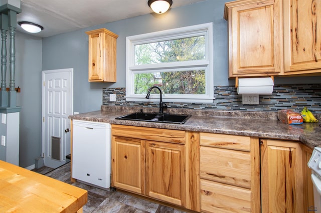 kitchen featuring white appliances, backsplash, light brown cabinetry, and a sink