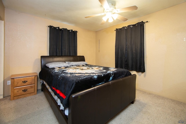 bedroom with light colored carpet and a ceiling fan