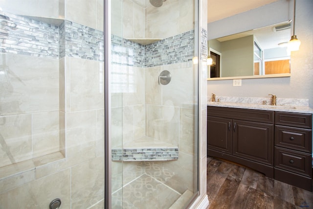 bathroom featuring vanity, wood finished floors, and a shower stall