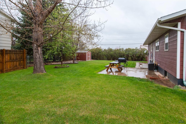 view of yard featuring a patio, fence, an outdoor structure, and a storage unit
