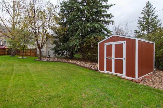 view of yard with a storage shed, an outdoor structure, and a fenced backyard