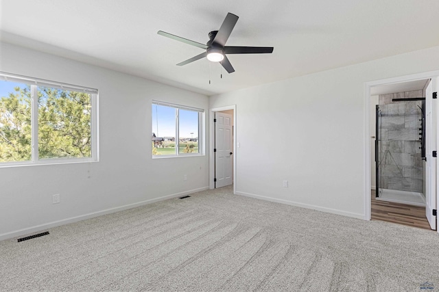 unfurnished bedroom featuring a ceiling fan, visible vents, baseboards, carpet flooring, and ensuite bath