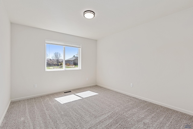 carpeted empty room with baseboards