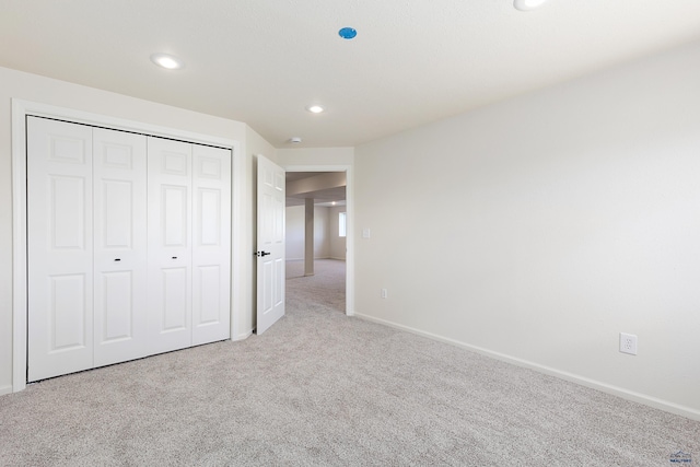 unfurnished bedroom with carpet flooring, recessed lighting, baseboards, and a closet