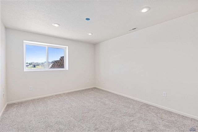 unfurnished room with carpet floors, baseboards, recessed lighting, and visible vents
