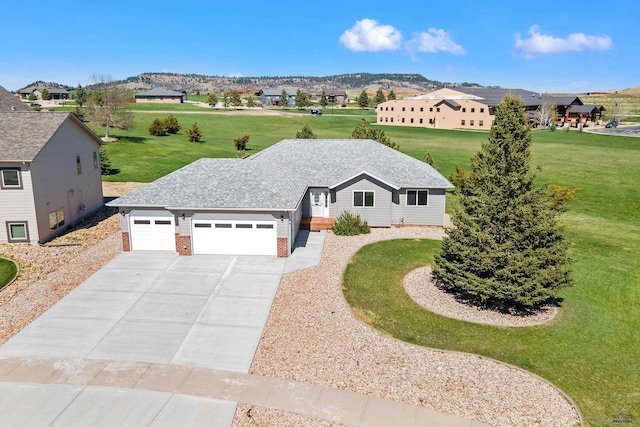 ranch-style home with driveway, a garage, brick siding, a mountain view, and a front lawn