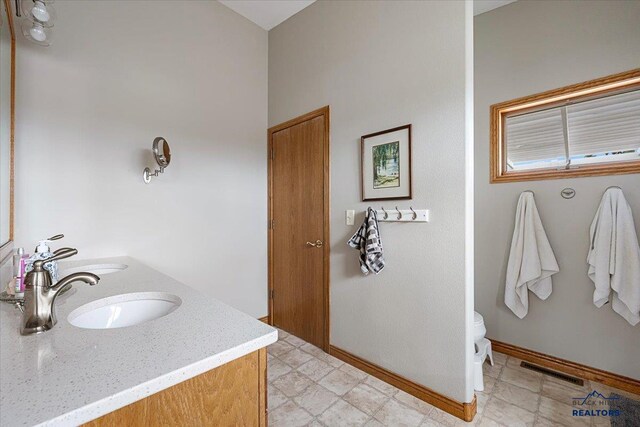 127 Union St, Spearfish, SD 57783 - bathroom featuring a sink, double vanity, toilet, baseboards, and visible vents