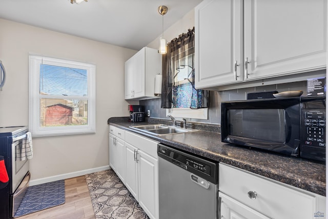 kitchen with black microwave, dark countertops, stainless steel dishwasher, a sink, and white cabinetry
