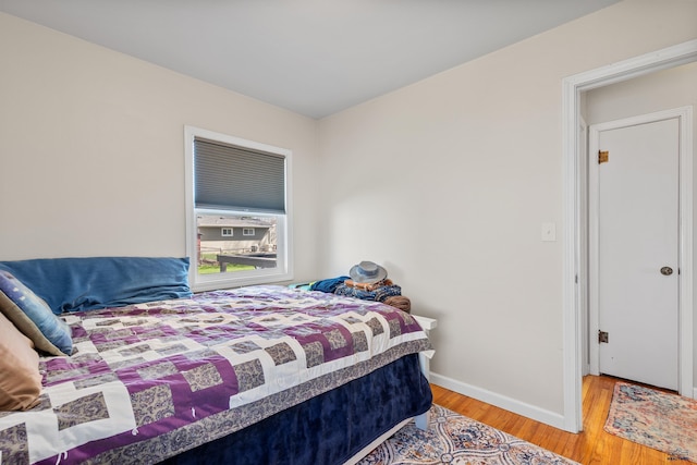 bedroom featuring baseboards and wood finished floors