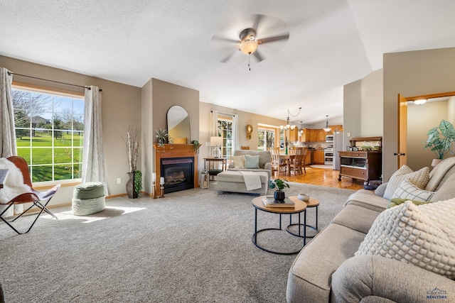 5201 Cale Ct, Rapid City, SD 57701 - living room featuring ceiling fan, light carpet, a glass covered fireplace, baseboards, and vaulted ceiling