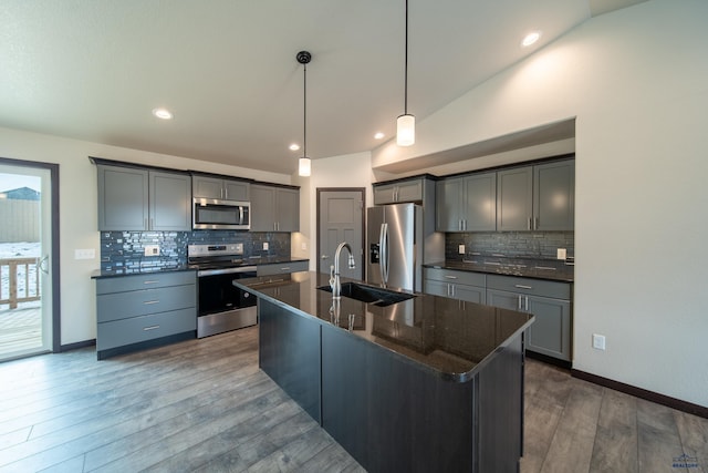 1241 Kenai Dr, Box Elder, SD 57719 - kitchen featuring dark wood-style flooring, tasteful backsplash, a sink, stainless steel appliances, and an island with sink