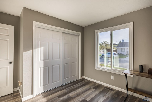 5235 Weathervane Ln, Rapid City, SD 57703 - unfurnished bedroom featuring a closet, dark wood finished floors, baseboards, and visible vents